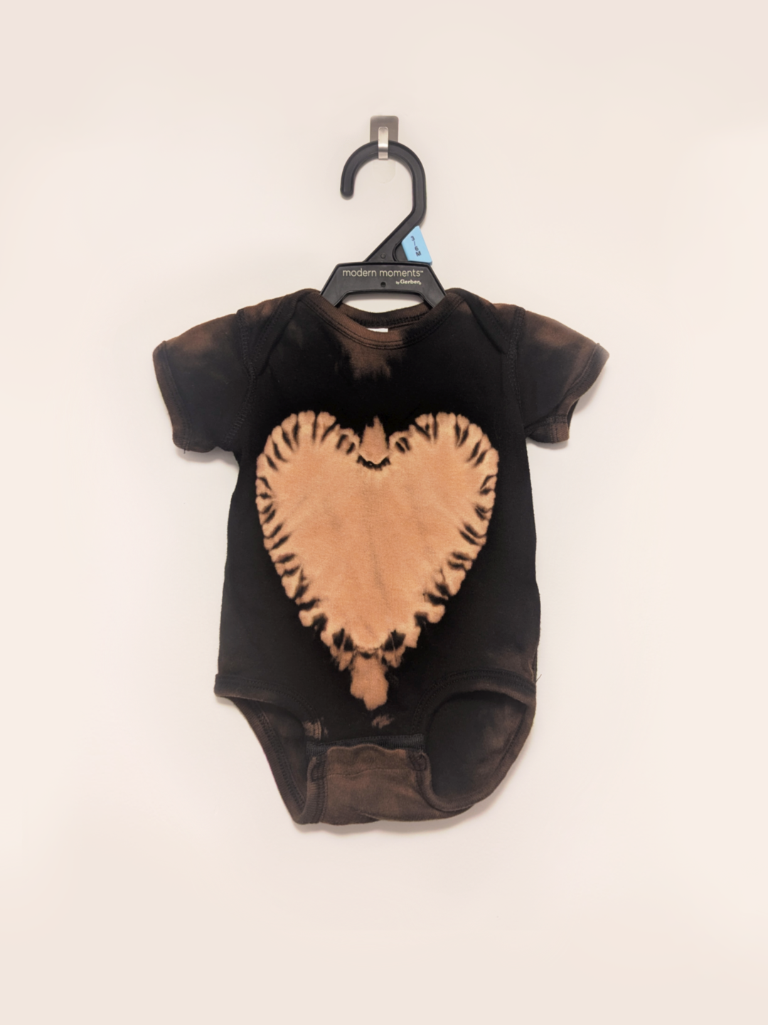 Black baby onesie with hand-bleached heart design in the center