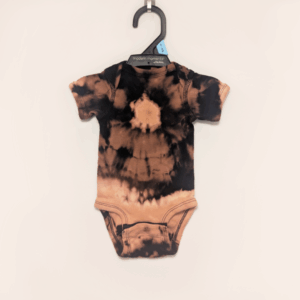 Black baby onesie with hand-bleached ringed design in the center