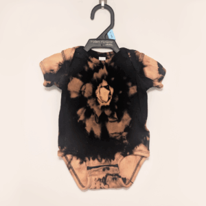 Black baby onesie with hand-bleached ringed design in the center