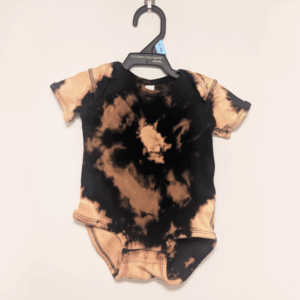 Black baby onesie with hand-bleached ringed design in the center